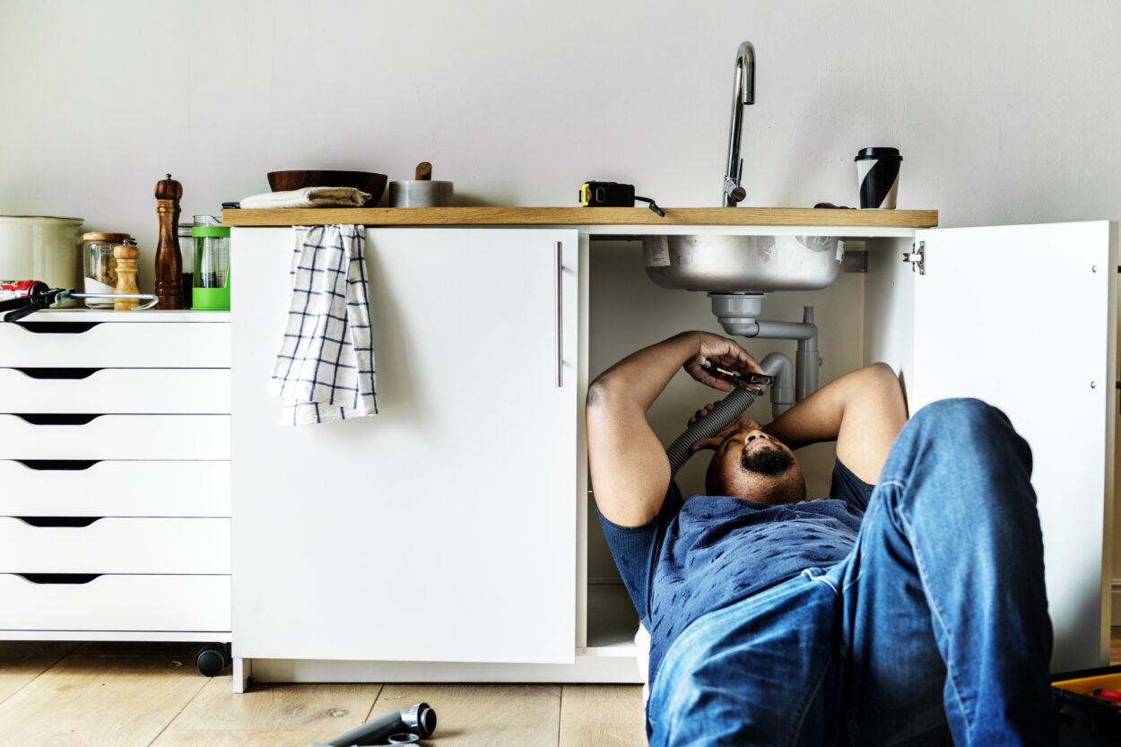 Plumber using a drain snake to clear a clogged drain in Massachusetts